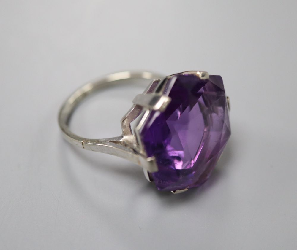 A white metal (stamped 18ct) and fancy hexagonal cut solitaire amethyst dress ring, size K, gross 6.3 grams.